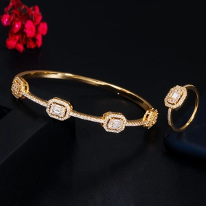 Macro shot of gold jewelry set with baguette-cut and halo-set zircon stones