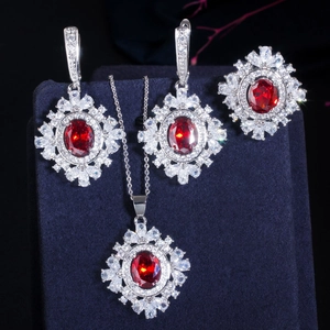Detail van rode edelsteen sieradenset met ketting, oorbellen en ring op fluwelen houder