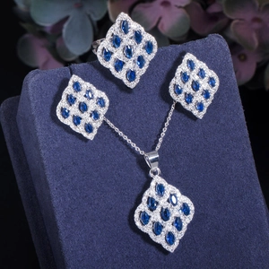 Detail of luxury jewelry set with marquise-cut blue zircon on navy velvet stand
