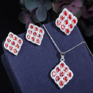 Detail of red marquise-cut zircon necklace and earrings set on blue velvet stand