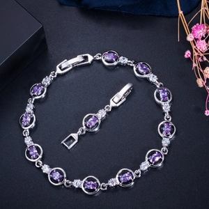 Close-up of silver-tone link bracelet with purple oval gemstones and white AAA zirconias