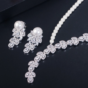 Detail of bridal jewelry set featuring pearl necklace and zircon leaf earrings