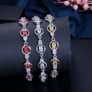 Detailed view of three zirconia bracelets with red, white, and yellow oval stones