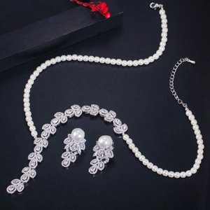 Detailed view of elegant pearl necklace and zircon earrings set on a dark textured background