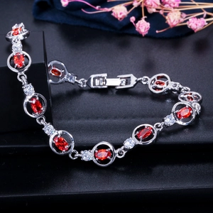 Macro shot of silver bracelet featuring oval red zircons and sparkling white stones