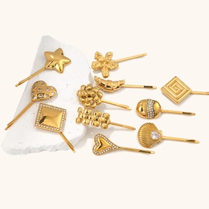 Vue macro de pinces à cheveux en acier plaqué or 18K avec étoiles et cœurs