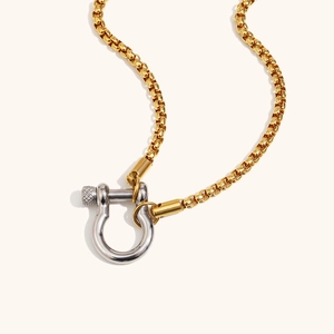 Détail d'un collier chaîne dorée à deux tons avec fermoir en U argenté texturé