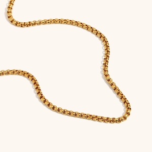 Vue macro d'une chaîne à mailles carrées en acier inoxydable doré à l'or 18 carats