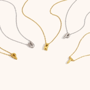 Polished 18K gold and silver bubble initial pendant necklaces on thin cable chains