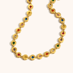 Macro detail of 18K gold plated necklace featuring vibrant colorful zircon gemstones