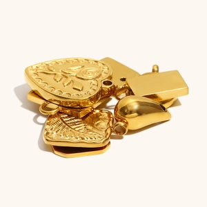 Macro detail of various 18K gold plated charms with rose relief and polished finishes