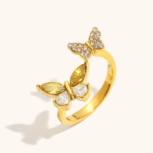 Detail eines Doppel-Schmetterlingsrings mit gelbem Zirkon und Kristallen in Goldoptik
