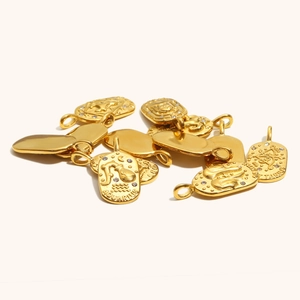 Detailed close-up of 18K gold plated stainless steel zodiac pendants with cubic zirconia