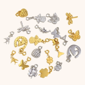 Various 18K gold and silver stainless steel pendants including clover and heart charms