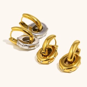 Minimalistische 18K vergoldete Creolen mit Zirkonia-Inlay auf cremefarbenem Hintergrund