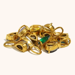 Macro detail of tear-drop jewelry pendants in 18K gold plating with vibrant gemstones