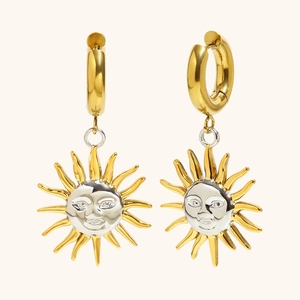Detail of two-tone sun face drop earrings with 18K gold plating and silver relief