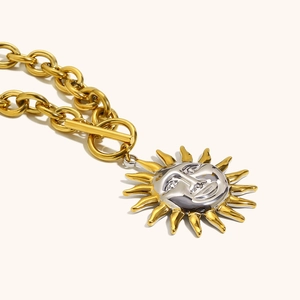 Close-up of vintage sun pendant necklace with 18K gold OT buckle and dual-tone finish