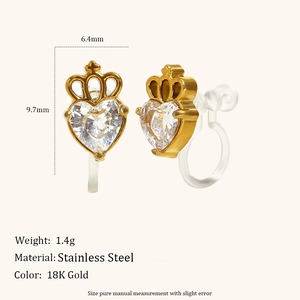 Dettaglio macro di orecchini a clip in acciaio placcato oro 18K con cuore in zirconia