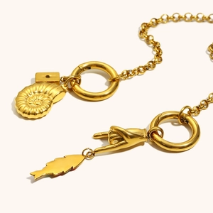 Dettaglio della collana placcata oro 18K con ciondoli a nautilus, mano e pesce