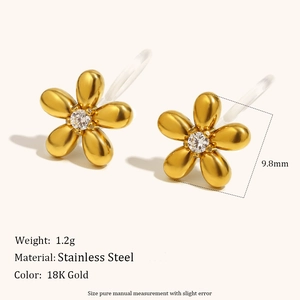 Dettaglio macro di orecchini a clip a fiore in oro 18K con zircone e resina