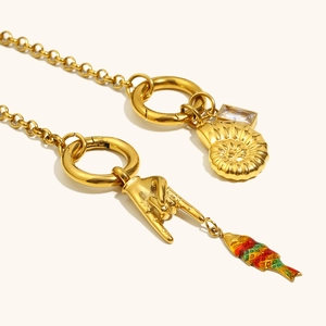 Dettaglio della catena placcata oro 18K con conchiglia a spirale e ciondolo pesce smaltato