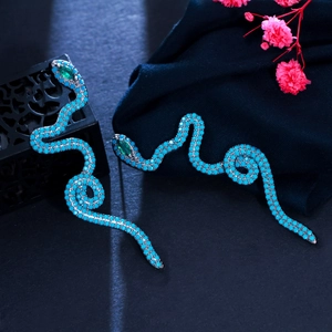 Detail of snake earrings with green turquoise beads and red emerald zircon eyes