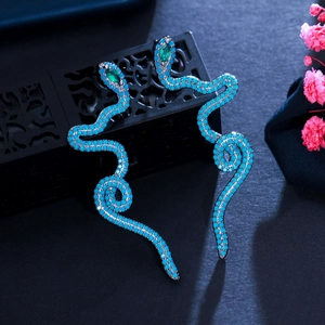 Snake drop earrings with sky blue beads and green stone eyes on black jewelry box
