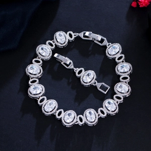 Detailed macro view of oval-cut zircon bracelet with micro-pave setting on black surface
