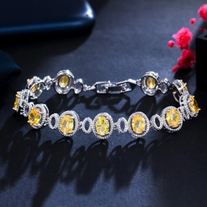 Macro detail of 18K gold plated bracelet with yellow zircon stones and white diamond accents