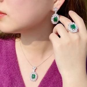 Elegante set di gioielli in argento con pietre verde smeraldo e zirconi su modella