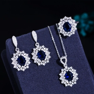 Detailed view of dark blue ruby jewelry set with oval gemstones and flower settings