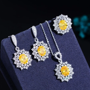 Detail of sunflower halo jewelry set featuring yellow gemstones on blue velvet