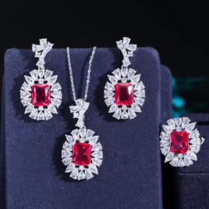Dettaglio del set gioielli con pietre rosse, collana, orecchini e anello su velluto blu