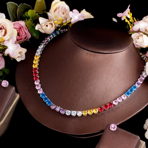 Conjunto de collar tennis arcoíris y pendientes rosas en busto de joyería