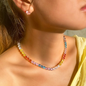 Conjunto de collar de tenis arcoíris y pendientes de piedra rosa lucidos por una modelo