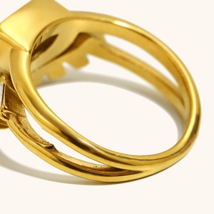 Detalle macro del anillo de doble capa chapado en oro 18K con piedra cuadrada y texturas