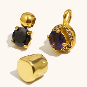 Close-up of 18K gold plated cylinder beads and round zircon pendants in black and purple