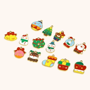 Nahaufnahme bunter Weihnachts-Emaille-Anhänger mit Schneemann und Nikolaus für DIY-Schmuck