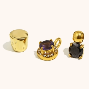 Detailed view of 18K gold plated cylindrical charm and round cubic zirconia pendants
