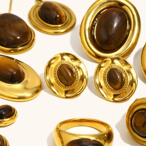Nahaufnahme von 18K vergoldetem Schmuckset mit ovalen Tigerauge-Steinen und gebürstetem Metall