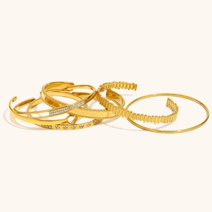 Dettaglio del set di bracciali minimalisti in oro 18 carati con cuore e forme geometriche
