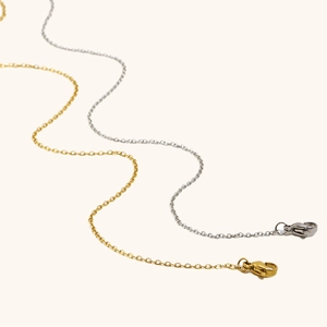 Dettaglio di catenine a maglia classica color oro e argento con chiusura a moschettone