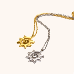 Detailansicht der Sonnen-Spiralanhänger in Gold und Silber mit polierter Metalloberfläche