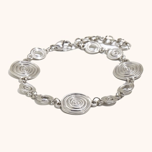 Bracelet en acier argenté avec breloques spirales concentriques et fermoir mousqueton