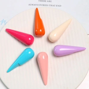 Polished resin teardrop pendants in six vibrant colors displayed on a white ceramic plate