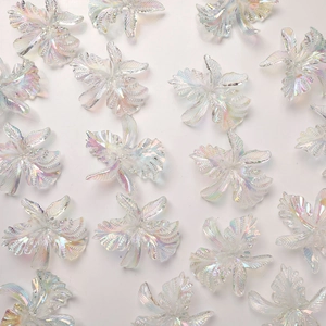 Detalle de dijes de flores de narciso acrílicas iridiscentes para bisutería DIY