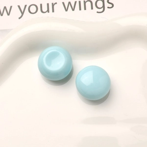 Close-up of light blue macaron resin button accessories on a decorative white plate