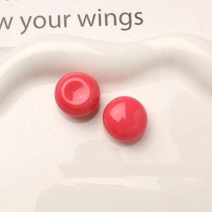 Macro shot of bright pink resin dome studs with glossy finish for DIY jewelry crafting