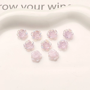 Detailed macro view of 10mm aurora resin camellia rose charms for DIY nail art designs